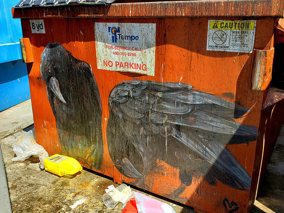 Wheatpaste painting of two crows on a large orange garbage bin